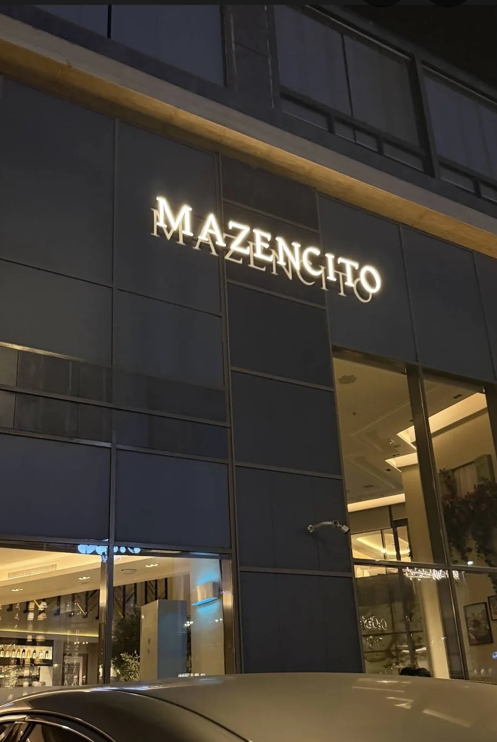 Mazencito Pizzeria illuminated signage on the building facade at night