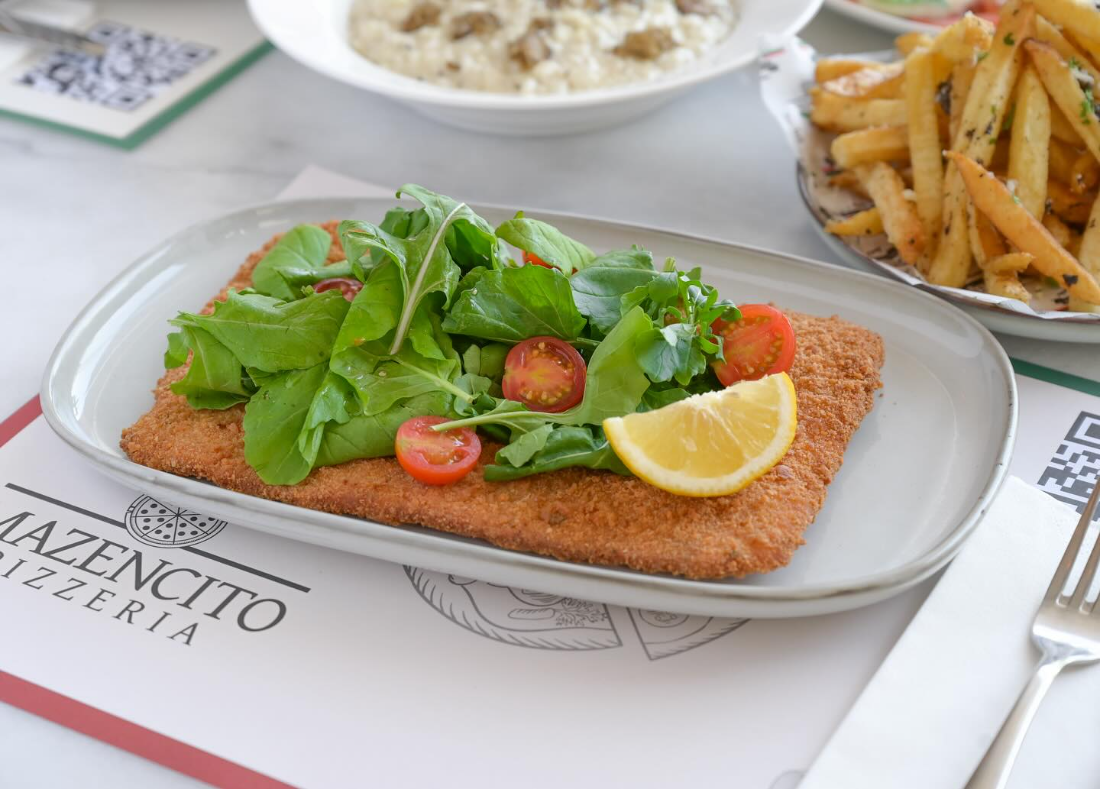 Schnitzel, risotto and fries on the table at Mazencito Pizzeria
