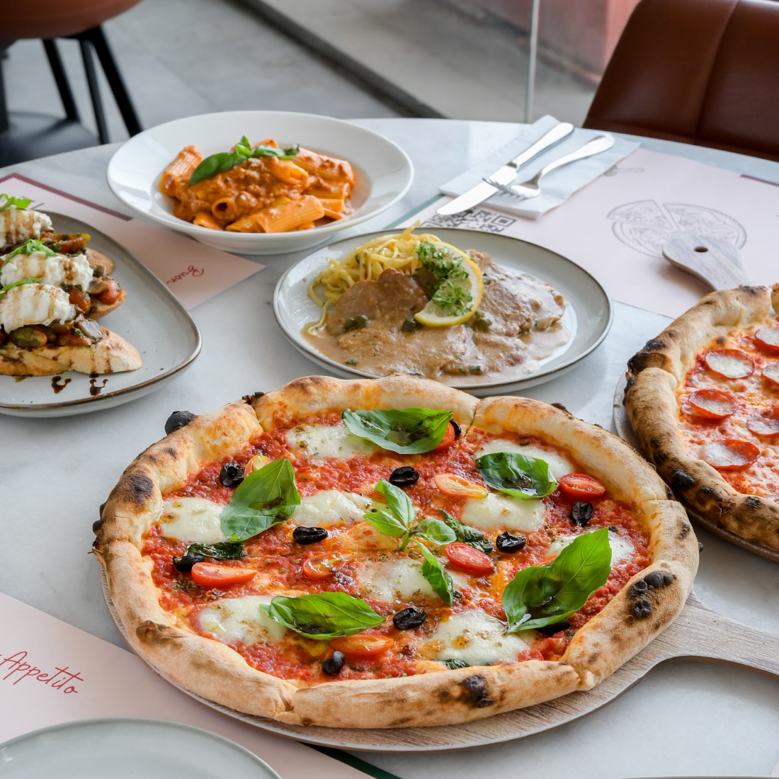 Pizza, pasta and veal piccata spread at Mazencito Pizzeria