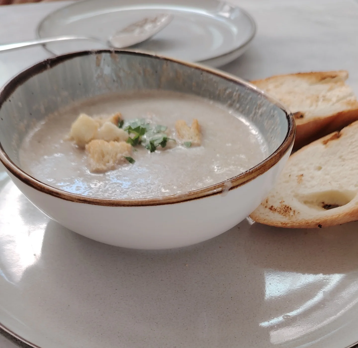 Creamy mushroom soup topped with mushroom slices